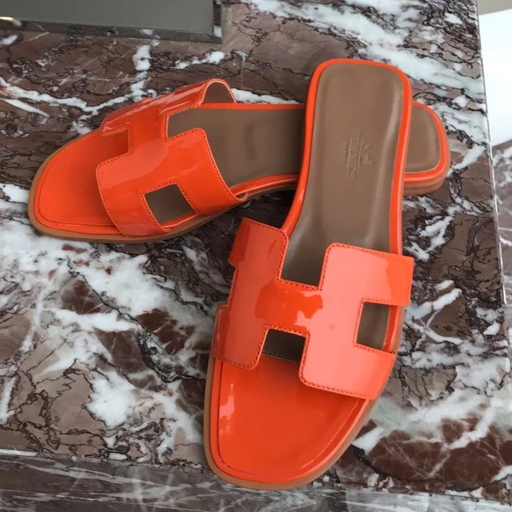 HERMES ORAN SLIDE SANDALS IN ORANGE PATENT CALFSKIN - HMSD085